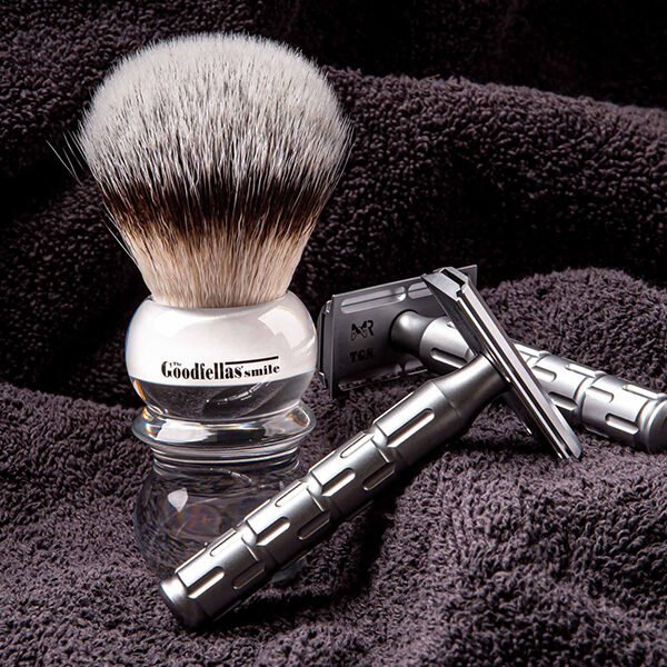 The Goodfellas' Smile Syntesi Safety Razor – Stainless Steel Three-Piece on towel with a brush