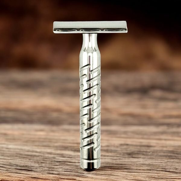 The Goodfellas’ Smile Styletto V2 stainless steel safety razor standing on wood surface, lifestyle shot