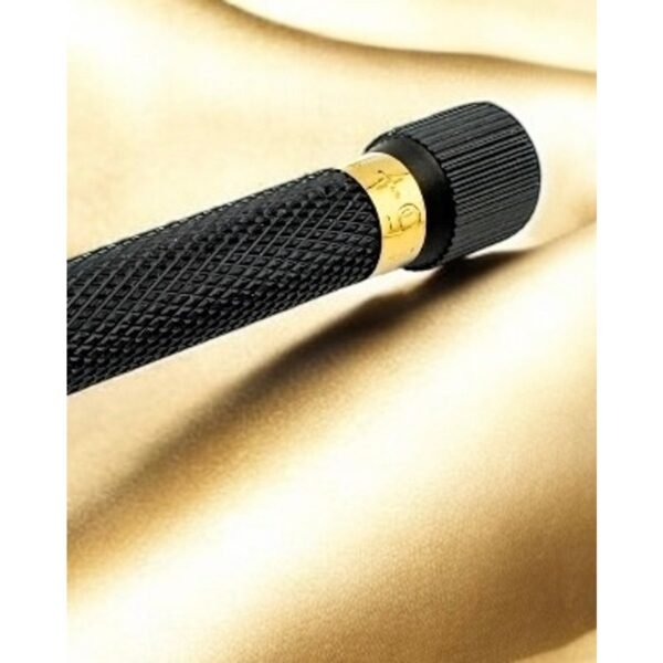 Close-up of gold adjustment ring and knurled black handle on gold satin backdrop